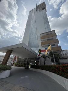 a tall white building with flags in front of it at Flat Moderno no Blue Tree Hotel in Manaus
