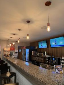 a bar in a restaurant with two televisions on the wall at Flat Moderno no Blue Tree Hotel in Manaus