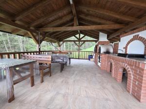 eine große Außenterrasse mit Tisch und Kamin in der Unterkunft Liniștea Codrului in Borşa