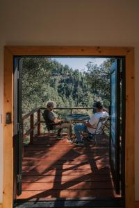 two men sitting at a table on a porch at Off-Grid Tiny Home Pacific Views & Serenity in Pauma Valley