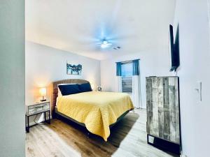 a bedroom with a bed with a yellow bedspread at Pelican Pointe Home for 10 in Bolivar Peninsula