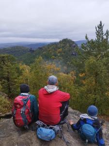 three people sitting on the edge of a mountain at Michas FeWo in Bautzen