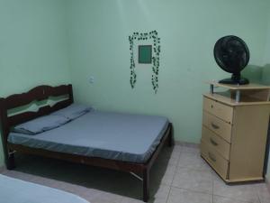 a small bedroom with a bed and a dresser at casa em Vila Verde Búzios in Búzios