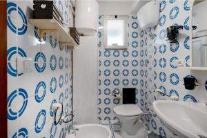 a bathroom with blue and white wallpaper and a toilet and sink at Due Passi Dal Mare in Torre a Mare +13 photos
