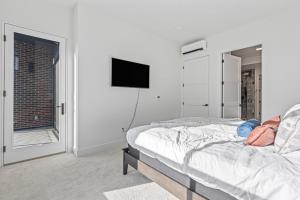 a white bedroom with a bed and a window at Serengeti Suite in Downtown Eagle in Eagle
