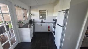 a kitchen with a white refrigerator and a sink at Tweed River Waterfront Cottage in Murwillumbah