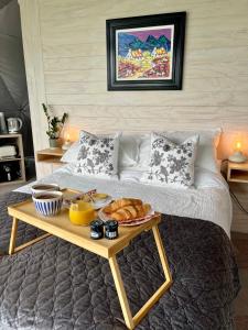 a bed with a tray of food on a table at The Dome at Midauchengowan in Lochwinnoch