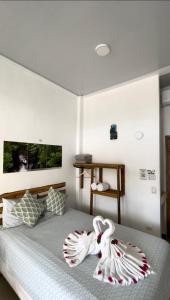 a bedroom with a bed with towels on it at Hotel Pura Natura Riverside Tortuguero in Tortuguero