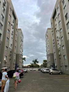 two people walking in a parking lot between tall buildings at Cantinho da Lyah in Torres