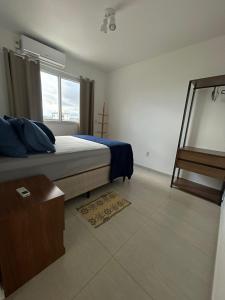 a bedroom with a bed and a window and a mirror at Cantinho da Lyah in Torres