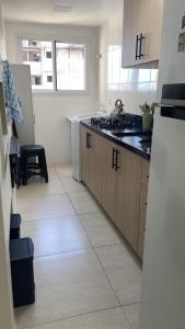 a kitchen with a sink and a refrigerator at Cantinho da Lyah in Torres