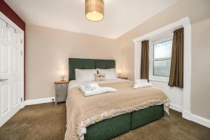 a bedroom with a large bed and a window at Burnside, Dornoch in Dornoch
