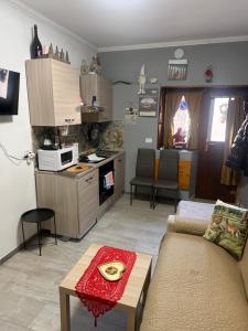 a living room with a couch and a kitchen at Casa Al Colle in Pescocostanzo