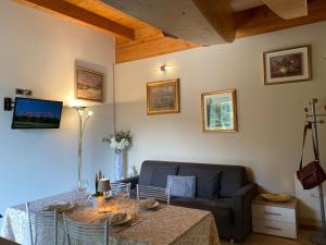 a living room with a table and a couch at APPARTAMENTO MONTE - VALANDRO- in Comano Terme