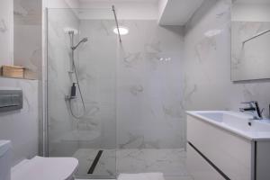 a bathroom with a shower and a toilet and a sink at Ivory Luxury 1BR in Voluntari +26 photos