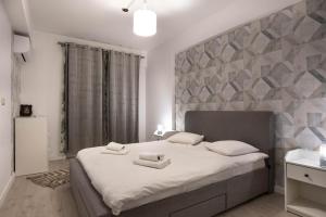 a bedroom with a large bed with two towels on it at Ivory Luxury 1BR in Voluntari