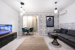 a living room with a couch and a tv and a table at Ivory Luxury 1BR in Voluntari