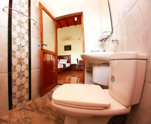 Łazienka z białą toaletą i umywalką w obiekcie Grand Residence w Tangalli
