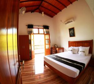 a bedroom with a bed and a large window at Grand Residence in Tangalle