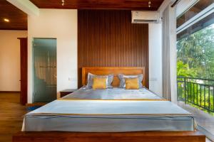 a bedroom with a large bed with a large window at Talpe Paradise in Galle