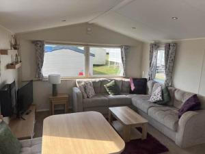 a living room with a couch and a table at Devon Cliff Breaks in Exmouth