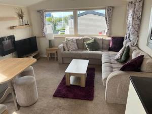a living room with a couch and a table at Devon Cliff Breaks in Exmouth +8 photos