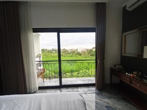 a bedroom with a bed and a view of a balcony at Santo Guesthouse in Canggu +5 photos
