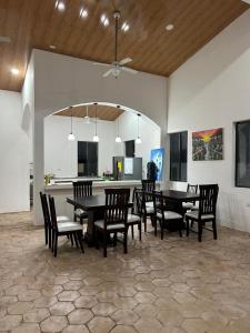 a dining room with tables and chairs and a kitchen at Casa 12-87 in Poneloya