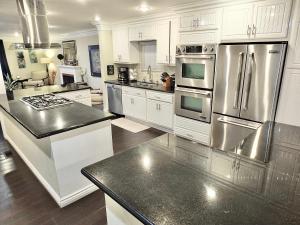 a kitchen with white cabinets and stainless steel appliances at LB Peninsula Steps to Beach close to in Long Beach