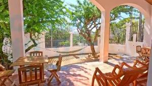 a patio with chairs and a hammock and a tree at Casa 12-87 in Poneloya