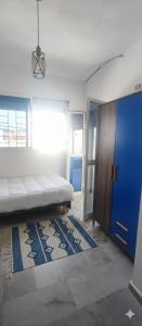 a living room with a couch and a blue door at Littlhouse in Rafrāf