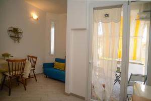 a living room with a blue couch and a glass door at GREGORIHOUSE Casa Giuditta in Anguillara Sabazia