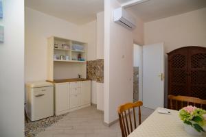 a kitchen with a table and a refrigerator at GREGORIHOUSE Casa Giuditta in Anguillara Sabazia
