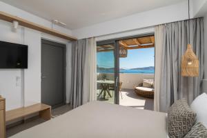 a bedroom with a bed and a view of the ocean at Etherio Suites Milos in Pollonia