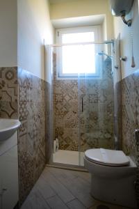 a bathroom with a shower with a toilet and a window at GREGORIHOUSE Casa Giuditta in Anguillara Sabazia