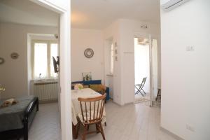 a kitchen and living room with a table and a chair at GREGORIHOUSE Casa Giuditta in Anguillara Sabazia +3 photos