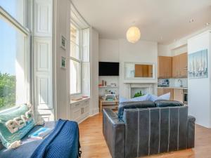 a living room with a couch and a kitchen at The Beach Studio in Brighton & Hove