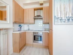 a kitchen with wooden cabinets and a sink at The Beach Studio in Brighton & Hove