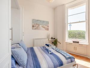 a white bedroom with a bed and a window at The Beach Studio in Brighton & Hove