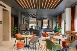 a restaurant with tables and chairs and a kitchen at Residence Inn Lisbon by Marriott Hotel in Lisbon