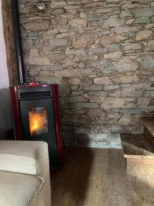 a stone wall with a stove in a room at La Casetta Prali in Prali