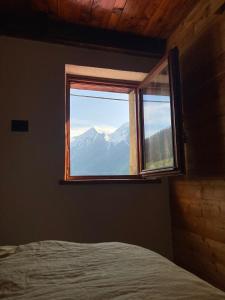 a bedroom with a window with a view of a mountain at La Casetta Prali in Prali