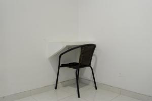 a black chair sitting in front of a white wall at Hotel Royal Classy in Villavicencio +3 photos