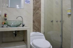 a bathroom with a toilet and a sink and a shower at Hotel Royal Classy in Villavicencio