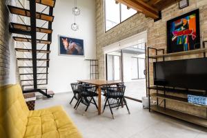a living room with a table and chairs and a tv at Bungalows in Samsara Atlixco in La Sabana
