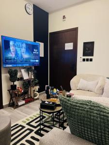 a living room with a couch and a tv at Modern Apartment 3 in Jeddah