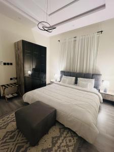 a large bedroom with a large white bed with a black headboard at Modern Apartment 3 in Jeddah