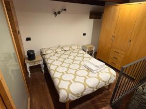 a small bedroom with a bed and a wooden cabinet at La Casetta Prali in Prali +5 photos