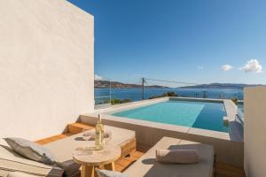 a villa with a swimming pool and a view of the ocean at Etherio Suites Milos in Pollonia