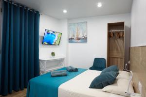 a bedroom with a bed and two blue chairs at Heaven Sea in Alicante
